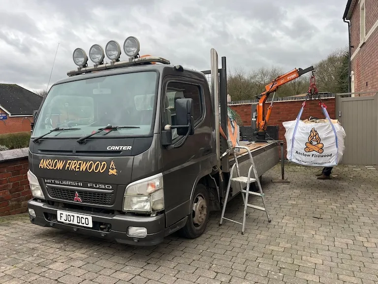 Delivery truck with firewood logs in bags